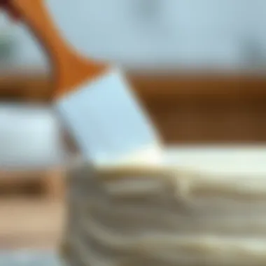 Close-up of an offset icing spatula in action smoothing icing on a cake