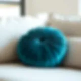 Luxurious teal round throw pillow on a modern sofa